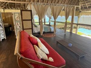 a room with a bed and a red couch at Palapa Ganesh in Sayulita