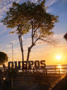 a sign in front of a tree and the sunset at Apartamento Chazu #3 in Quepos