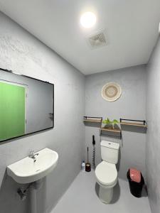 a bathroom with a white toilet and a sink at Jaydy Guest House in General Luna