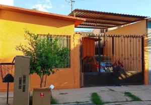 a yellow and orange house with a gate and a car at Connected House in Torreón in Torreón