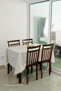 a dining room table with four chairs and a white table cloth at Mesahill Home Stay Nilai in Nilai