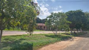 a dirt road with trees in front of a house at Suíte Morada das Mangueiras Térreo in Soure