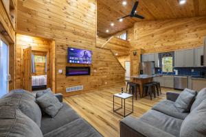 a living room with a couch and a kitchen at New listing-- Hocking Hills Modern Cabin in Logan