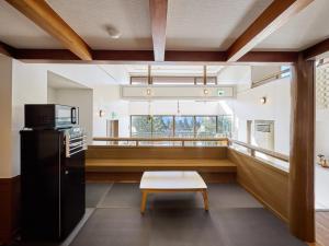 a kitchen with a bench and a table in a room at Oyado S in Hakone
