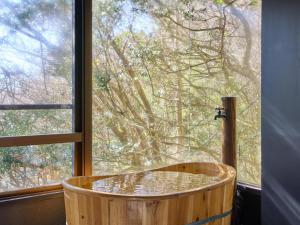 a wooden tub in front of a window at Oyado S in Hakone