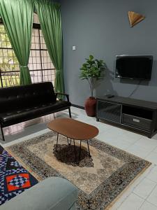 a living room with a couch and a coffee table at ROSSA Condo 1 in Kuah