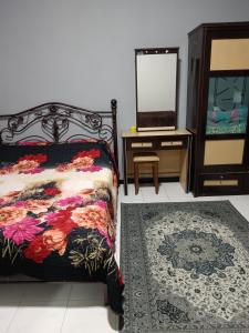 a bedroom with a bed and a dresser and a mirror at ROSSA Condo 1 in Kuah
