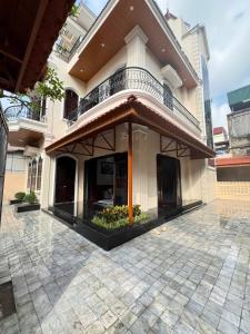 a house with a balcony on top of a courtyard at Đậu Homestay Phố Cổ in Ninh Binh