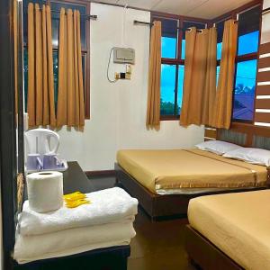 a room with two beds and a table with towels at Johans Chalet & Restaurant in Tioman Island