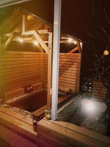 a wooden sauna at night with lights at saunalu in Kido