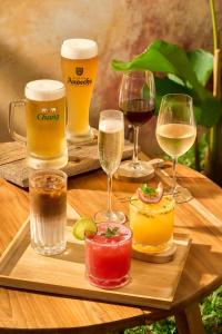 a wooden table with glasses of beer and drinks at THANYAWANA Glamping Tents in Khao Sok National Park