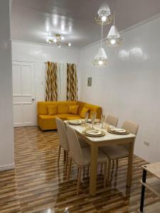 a living room with a table and a yellow couch at Kole & Kobe Haven in Dipolog