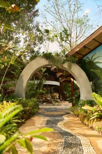 a stone path leading to a building with an archway at THANYAWANA Glamping Tents in Khao Sok National Park