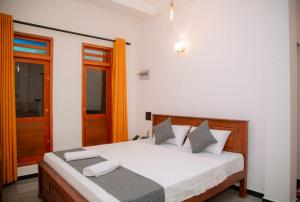 a bedroom with a bed with white sheets and an open door at Mond Villa Weligama - Private Surf & Nature Stay near Beach in Weligama