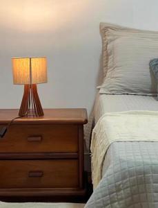 a nightstand with a lamp on it next to a bed at Estadia central bh in Belo Horizonte