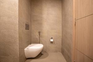 a bathroom with a toilet and a toilet paper dispenser at The Sterling Omaxe Near Expo Mart in Greater Noida +16 photos