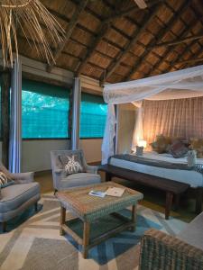 a bedroom with a bed and a couch and a table at Thornicroft Lodge - South Luangwa in Mfuwe +90 photos