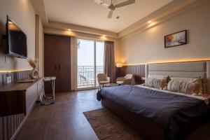 a hotel room with a bed and a balcony at The Sterling Omaxe Near Expo Mart in Greater Noida