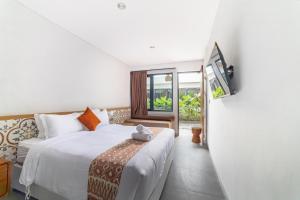 a hotel room with a bed and a tv at Padinis Villa & Coffee in Ketewel +83 photos