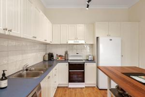 a white kitchen with a sink and a refrigerator at Surf Beach Remote Retreat in Surf Beach