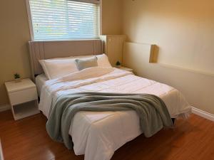 a bedroom with a bed with a blanket and a window at Spacious 2 Bedroom Suite in Delta