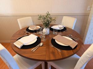 a wooden table with plates and wine glasses on it at Spacious 2 Bedroom Suite in Delta +1 photo