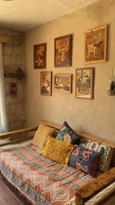 a bed in a room with pictures on the wall at Beit Al Rahi in Ḑahr al Ḩarf