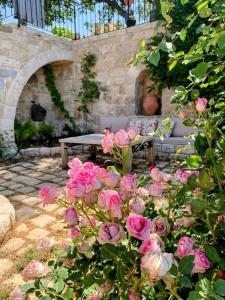 a bunch of pink roses in a garden with a bench at Beit Al Rahi in Ḑahr al Ḩarf
