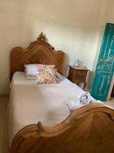 a bedroom with a bed with a wooden head board at Beit Al Rahi in Ḑahr al Ḩarf +11 photos