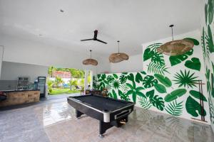 a pool table in a room with a wall with plants at Wanderlust Hostel - Highest Privacy Hostel In Kuta - Big Clear Pool - Fast Internet in Kuta Lombok +24 photos