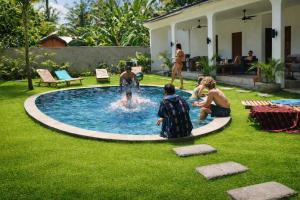 a group of people playing in a swimming pool at Wanderlust Hostel - Highest Privacy Hostel In Kuta - Big Clear Pool - Fast Internet in Kuta Lombok