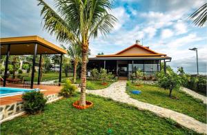 a house with a palm tree and a swimming pool at Palisade Garden in Ấp Thiện Sơn