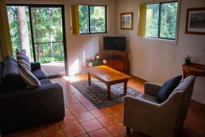 a living room with a couch and a coffee table at LAKE VIEW CHALET Australia Zoo close by in Landsborough
