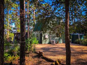 a green cabin in the middle of trees at LAKE VIEW CHALET Australia Zoo close by in Landsborough