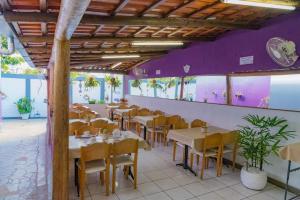 a restaurant with tables and chairs and purple walls at Pousada ExpoBH in Belo Horizonte