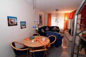 a living room with a table and a blue couch at Haus Siegfried Appartements in Xanten
