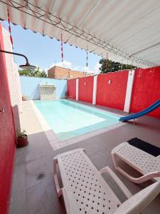 a swimming pool with a hammock and chairs on a patio at Casa con piscina privada Girardot in Girardot