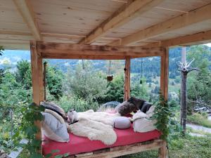 a bed in a pergola with people laying on it at Alp Chnorz Penthouse in Nesslau