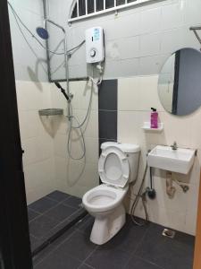 a bathroom with a shower and a toilet and a sink at ROSSA Condo 1 in Kuah +6 photos