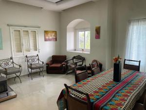 a living room with a table and chairs at beit al moukhtar in Ḩārat at Taḩtā