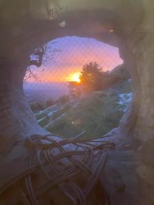 a view of a sunset through a stone window at beit al moukhtar in Ḩārat at Taḩtā