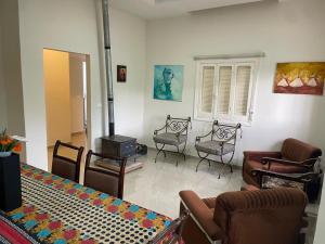 a living room with chairs and a fireplace at beit al moukhtar in Ḩārat at Taḩtā +12 photos