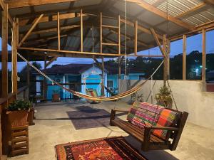 a porch with a hammock and a swing at Casa Maruka in San Ignacio