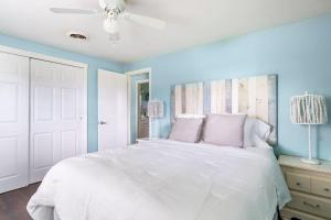 a bedroom with a white bed and blue walls at Lemon Bay Hideaway, Retro Beach Bungalow in Venice