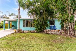 a blue house with palm trees and a yard at Lemon Bay Hideaway, Retro Beach Bungalow in Venice