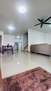 a living room with a couch and a ceiling fan at Kitjamyhome2 in Ban Tha Thon