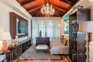 a living room with a couch and a chandelier at Arun Rapee Villa Surin Beach in Surin Beach