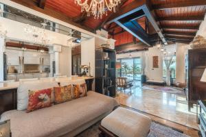 a living room with a couch and a kitchen at Arun Rapee Villa Surin Beach in Surin Beach