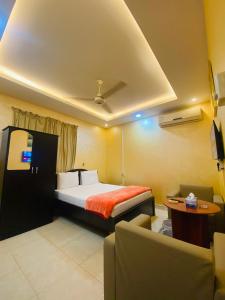 a hotel room with a bed and a table and chairs at AL FANAR REST HOUSE LLC in Ras al Khaimah +3 photos