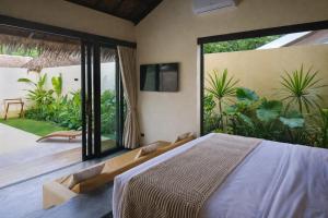 a bedroom with a bed and a large window at Nala Villas in General Luna
